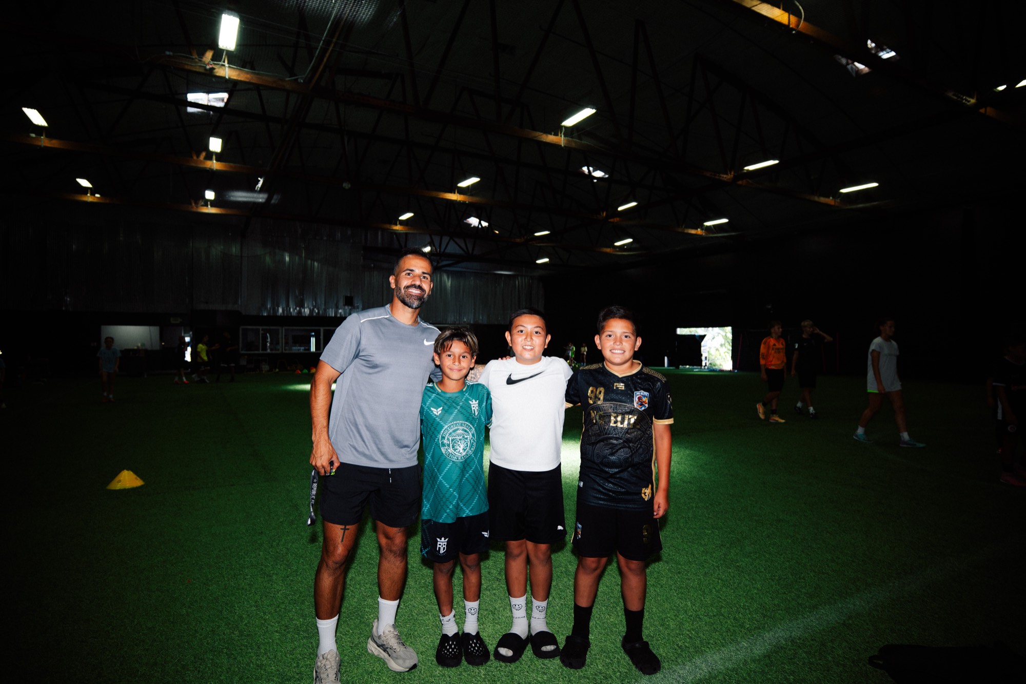 Roro López coaching young players on an indoor turf field in Sacramento